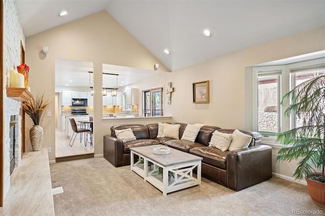 living area with recessed lighting, light colored carpet, a fireplace, and high vaulted ceiling