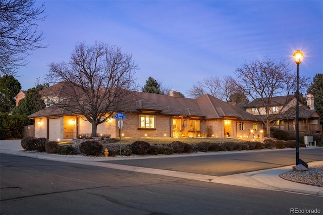 view of front of house featuring an attached garage and a chimney