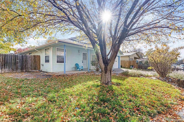 view of front of home with a patio area, a front yard, and fence