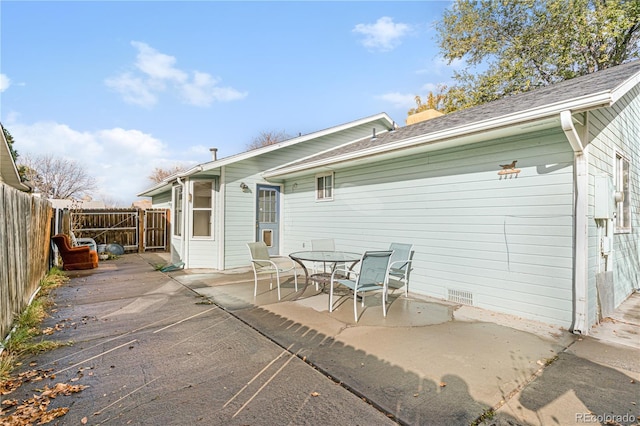rear view of house featuring fence and a patio area