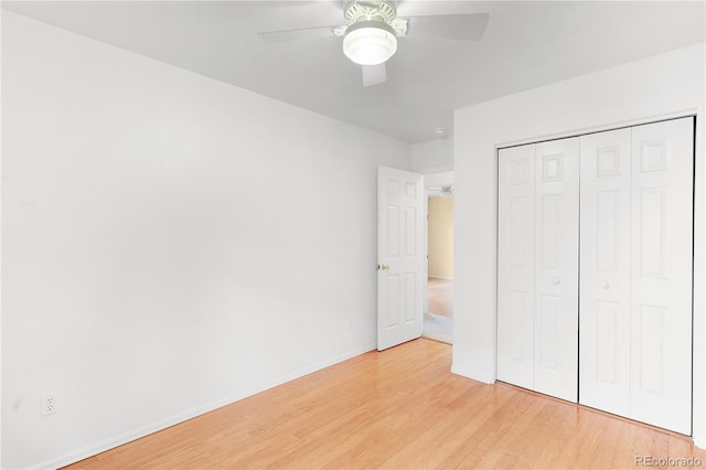 unfurnished bedroom with baseboards, a closet, light wood finished floors, and ceiling fan