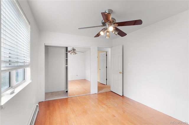 unfurnished bedroom featuring light wood-type flooring, a closet, ceiling fan, and a baseboard radiator