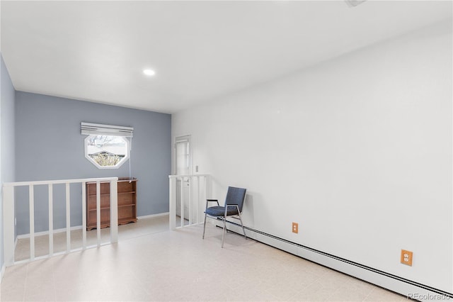 unfurnished room featuring a baseboard heating unit, tile patterned floors, and baseboards