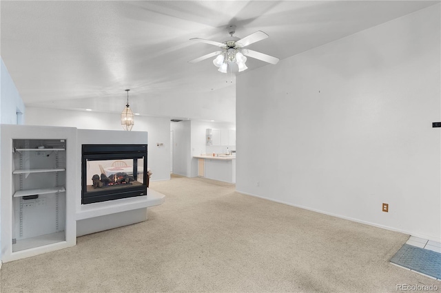 unfurnished living room featuring light carpet, lofted ceiling, a ceiling fan, a multi sided fireplace, and baseboards