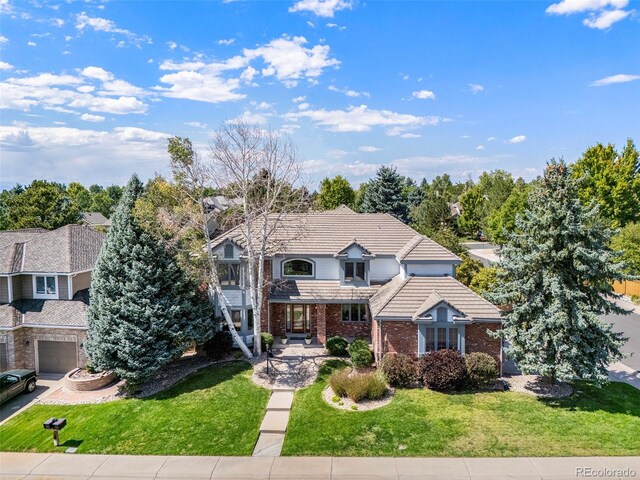 view of property featuring a garage and a front lawn