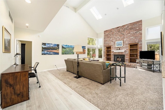 living room with a fireplace, light wood-type flooring, beamed ceiling, high vaulted ceiling, and a skylight