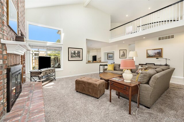 carpeted living room with high vaulted ceiling, beamed ceiling, and a brick fireplace