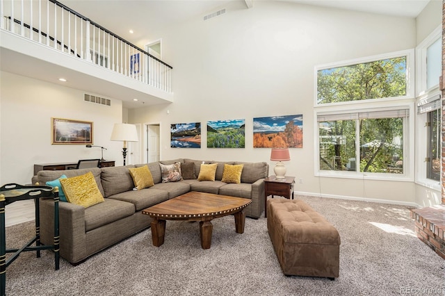 carpeted living room with high vaulted ceiling