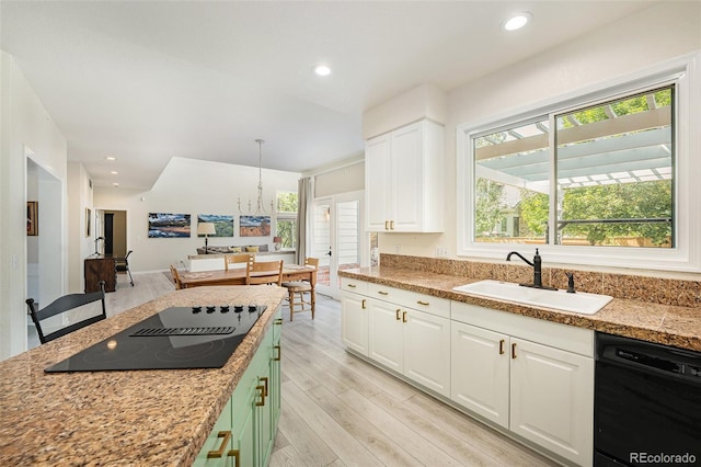 kitchen featuring black appliances, a wealth of natural light, light hardwood / wood-style floors, and sink