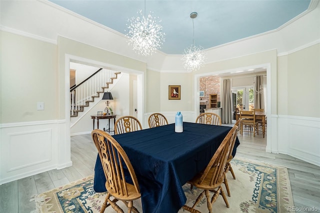 dining room featuring ornamental molding, an inviting chandelier, and light hardwood / wood-style floors