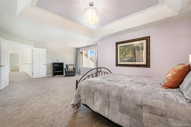 bedroom featuring a tray ceiling, an inviting chandelier, and carpet