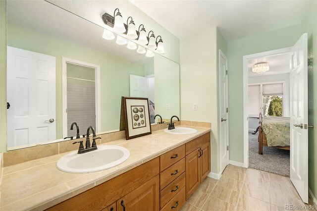 bathroom featuring tile patterned flooring, vanity, and a shower