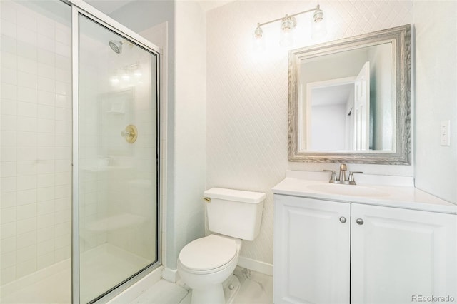 bathroom with a shower with shower door, toilet, and vanity