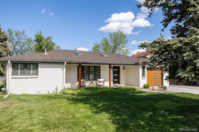 3540 Everett St, Wheat Ridge, CO 80033 - view of front facade featuring brick siding, a front yard, a chimney, and driveway