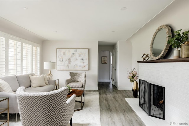 3540 Everett St, Wheat Ridge, CO 80033 - living area with wood finished floors, baseboards, and a brick fireplace
