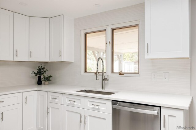 3540 Everett St, Wheat Ridge, CO 80033 - kitchen featuring stainless steel dishwasher, a sink, backsplash, and white cabinets