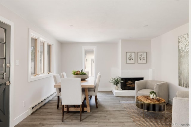 3540 Everett St, Wheat Ridge, CO 80033 - dining space with a baseboard radiator, wood finished floors, baseboards, and a fireplace