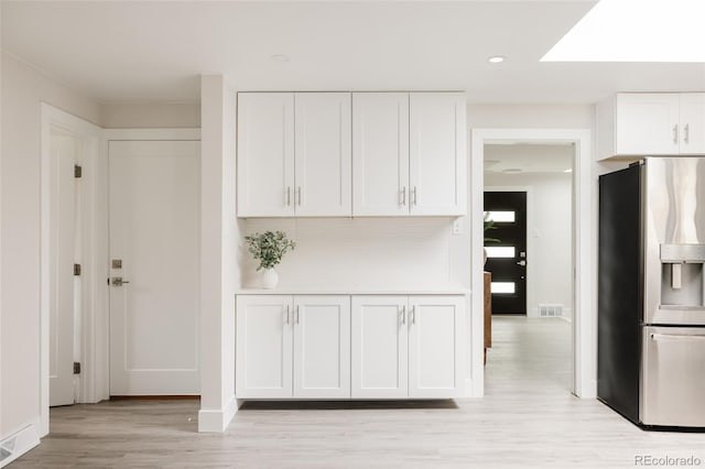 3540 Everett St, Wheat Ridge, CO 80033 - kitchen with stainless steel fridge with ice dispenser, light wood finished floors, white cabinetry, baseboards, and recessed lighting