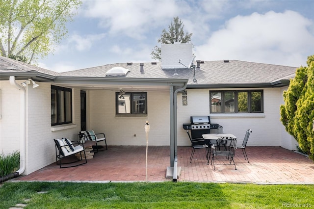 3540 Everett St, Wheat Ridge, CO 80033 - back of house featuring a patio area, a chimney, brick siding, and roof with shingles