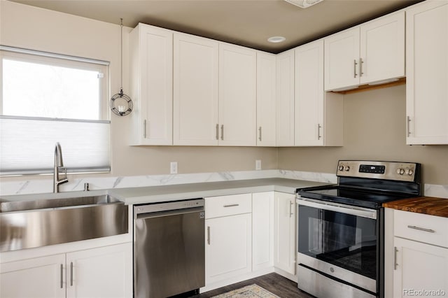 3540 Everett St, Wheat Ridge, CO 80033 - kitchen with appliances with stainless steel finishes, a sink, and white cabinets