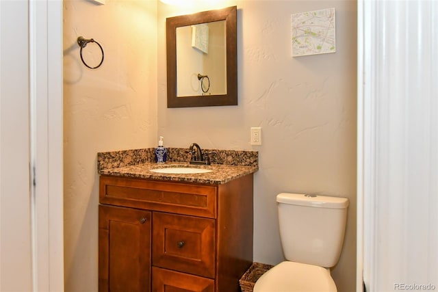 half bathroom featuring toilet and vanity