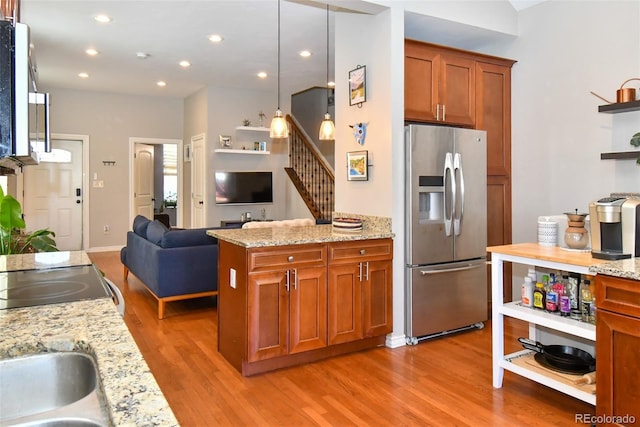 kitchen with light wood finished floors, brown cabinets, open floor plan, stainless steel refrigerator with ice dispenser, and open shelves