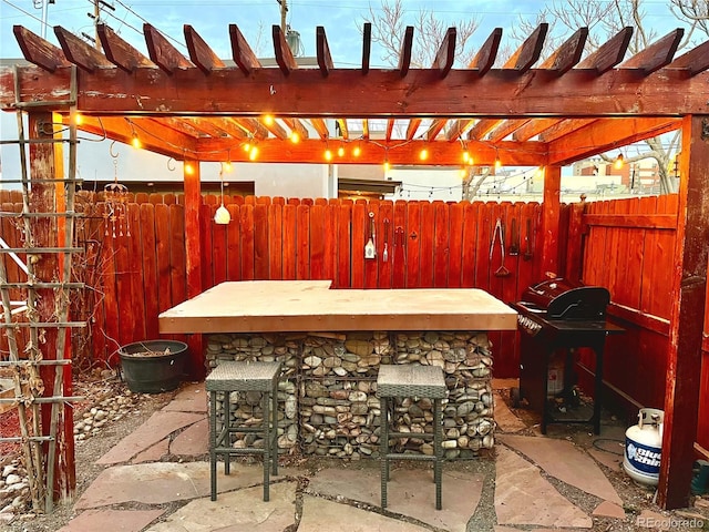 view of patio featuring outdoor dry bar, area for grilling, fence, and a pergola