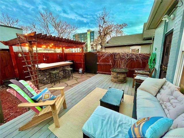 wooden deck with a fenced backyard, outdoor dry bar, outdoor lounge area, and a pergola