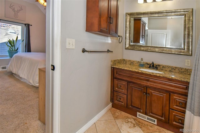 bathroom with visible vents, baseboards, ensuite bath, tile patterned floors, and vanity