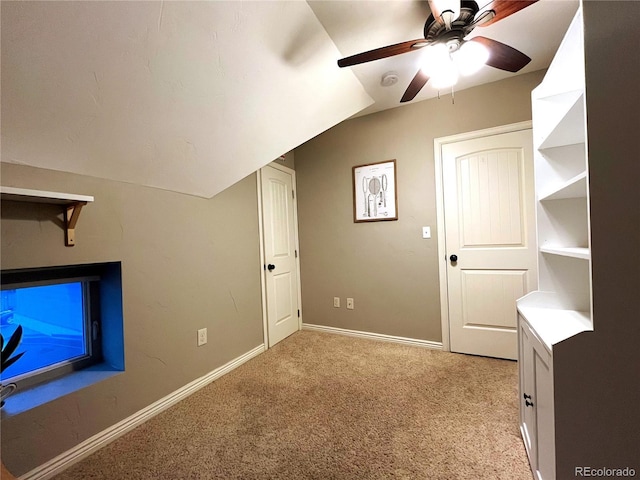 bonus room featuring light carpet, vaulted ceiling, a ceiling fan, and baseboards