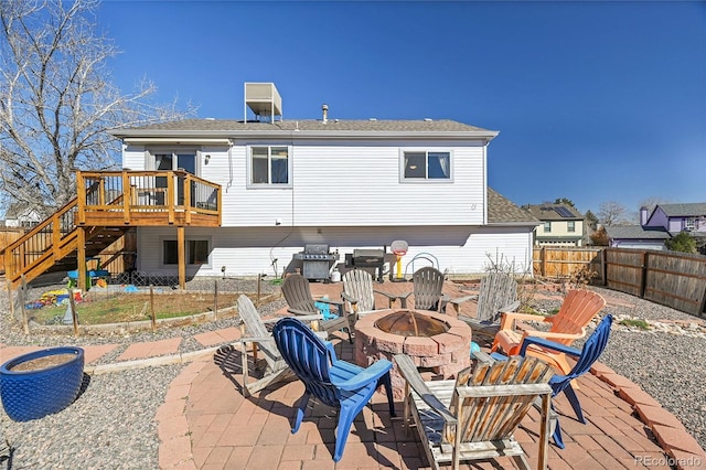 back of property featuring a fire pit, stairs, fence, a wooden deck, and a patio area