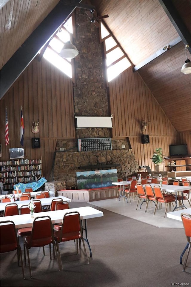 interior space featuring lofted ceiling, carpet floors, wooden ceiling, ceiling fan, and wooden walls