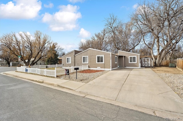 view of front of home with a fenced front yard, a storage shed, and an outbuilding