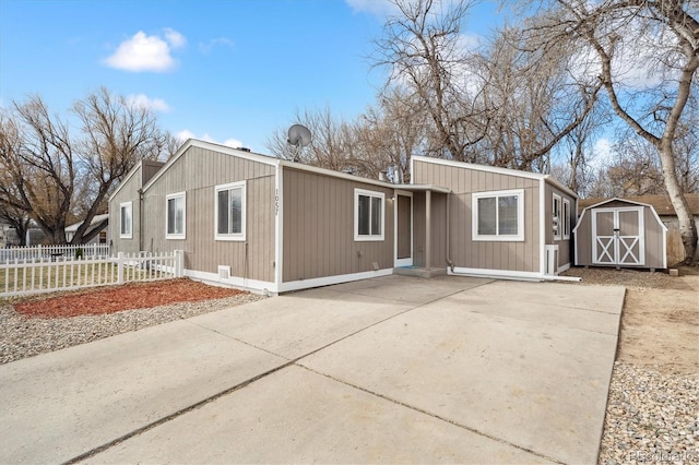 view of front of property with fence, an outdoor structure, and a shed