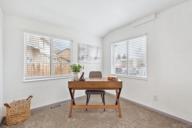 carpeted office featuring lofted ceiling, visible vents, and baseboards