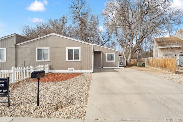 view of front of house featuring concrete driveway and fence