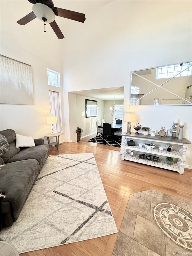 8769 S Dudley St, Littleton, CO 80128 - living area with baseboards, a high ceiling, ceiling fan with notable chandelier, and wood finished floors