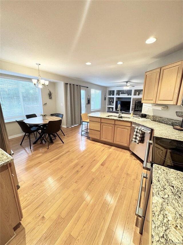 8769 S Dudley St, Littleton, CO 80128 - kitchen featuring light brown cabinetry, light wood-type flooring, a peninsula, and appliances with stainless steel finishes