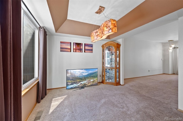 8441 Urban Ct, Arvada, CO 80005 - unfurnished living room with carpet flooring, visible vents, a tray ceiling, and baseboards