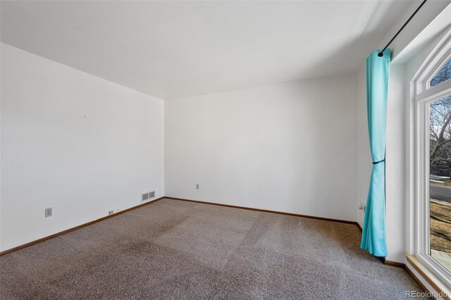 8441 Urban Ct, Arvada, CO 80005 - carpeted spare room featuring baseboards, visible vents, and a wealth of natural light