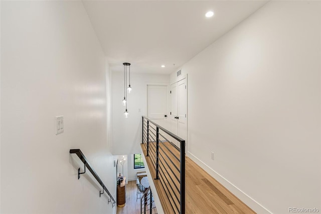 stairs with baseboards, wood finished floors, visible vents, and recessed lighting
