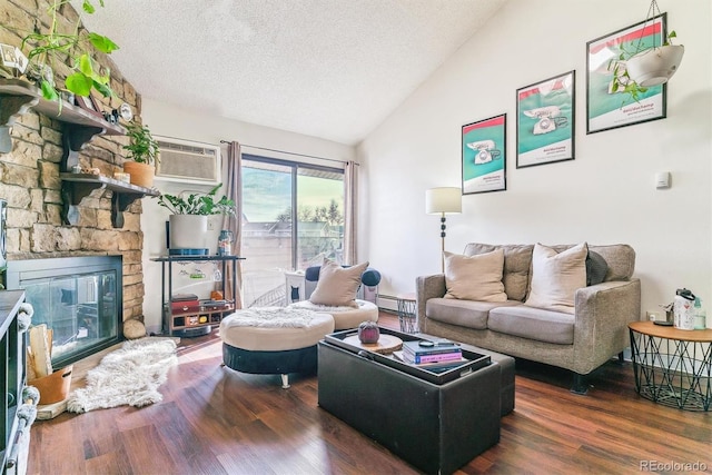 living room with a wall unit AC, a stone fireplace, dark hardwood / wood-style flooring, and a textured ceiling