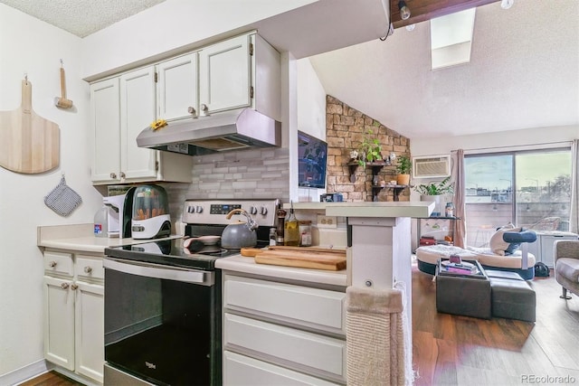 kitchen featuring electric stove, white cabinetry, a textured ceiling, and wood-type flooring