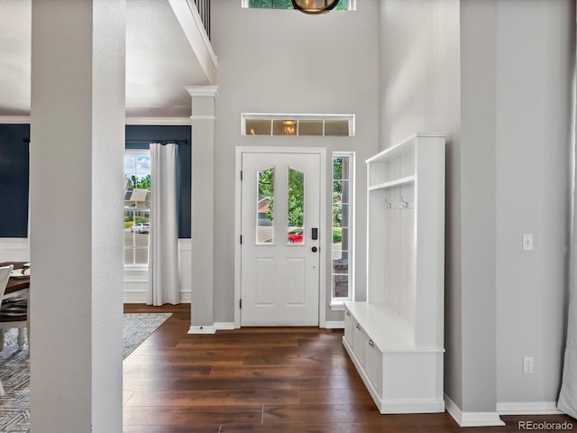 3043 W 109th Pl, Westminster, CO 80031 - entryway with dark wood-style flooring, a towering ceiling, and decorative columns