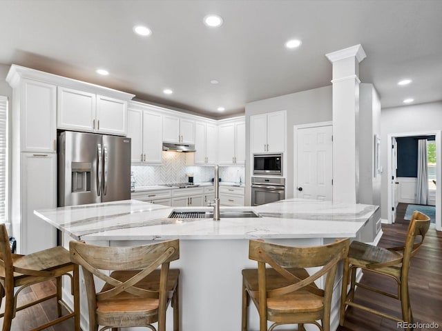 3043 W 109th Pl, Westminster, CO 80031 - kitchen featuring appliances with stainless steel finishes, under cabinet range hood, white cabinets, recessed lighting, and backsplash