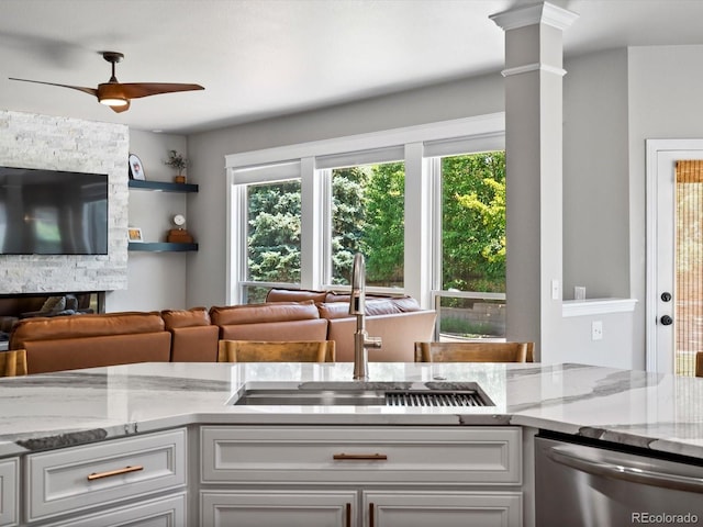 3043 W 109th Pl, Westminster, CO 80031 - kitchen with stainless steel dishwasher, healthy amount of natural light, open floor plan, and light stone countertops