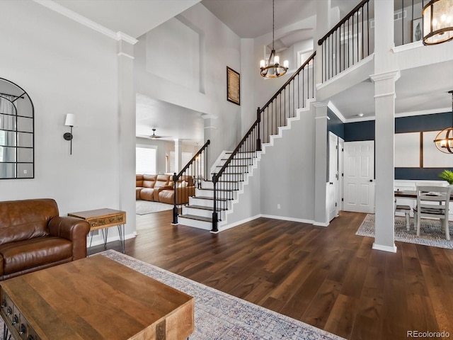 3043 W 109th Pl, Westminster, CO 80031 - entryway featuring decorative columns, a chandelier, dark wood-style floors, a towering ceiling, and stairway