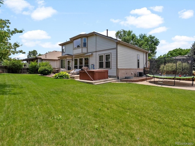 3043 W 109th Pl, Westminster, CO 80031 - rear view of house featuring a hot tub, a trampoline, a lawn, and a patio
