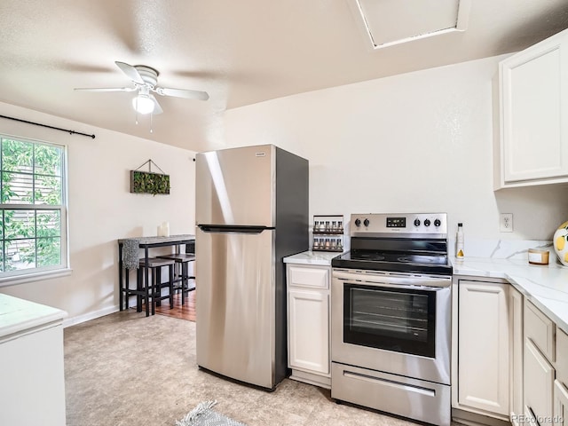 3304 W 3rd Ave, Denver, CO 80219 - kitchen featuring stainless steel appliances, a ceiling fan, light flooring, white cabinetry, and light stone counters