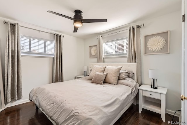 bedroom featuring multiple windows, baseboards, and dark wood-style flooring